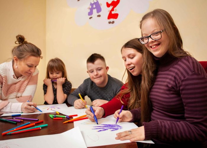 happy-girl-with-down-syndrome-posing-while-drawing_11zon-scaled-min